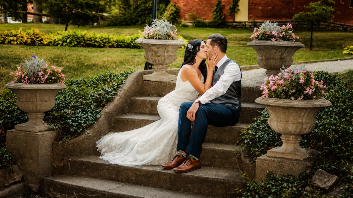 A couple shares a kiss on the garden steps