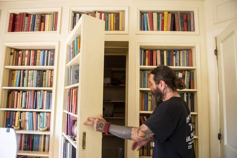 A hidden door in the library bookcase opens to one of the mansion’s secret rooms