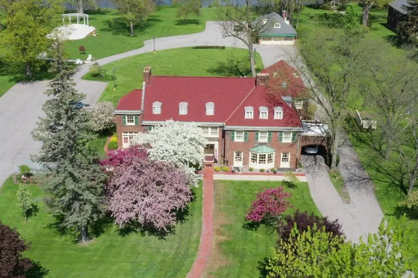 An aerial view of the mansion, carriage house, and eight acres of grounds beside Lake Linton